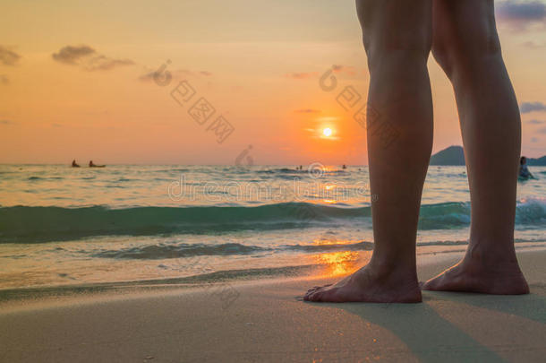 日落时脚踩在沙子上。