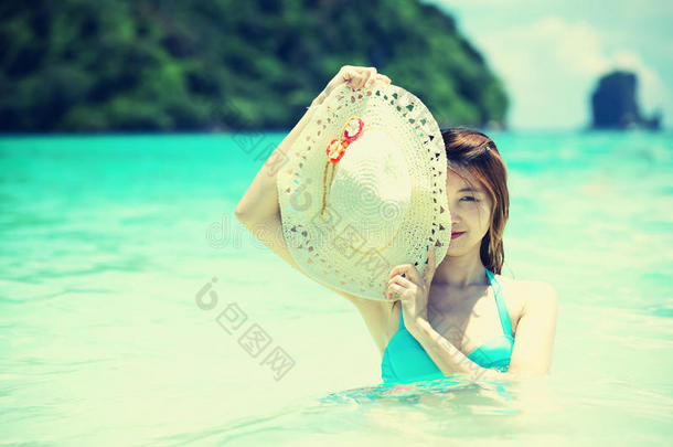亚洲美丽的年轻女人戴着比基尼在海滩上