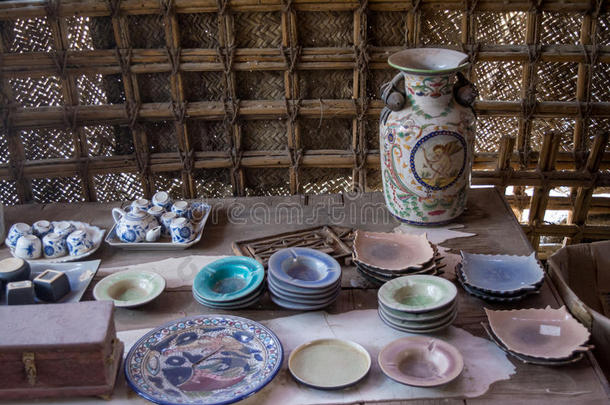 桌子上有水壶、盘子和茶壶的古代人