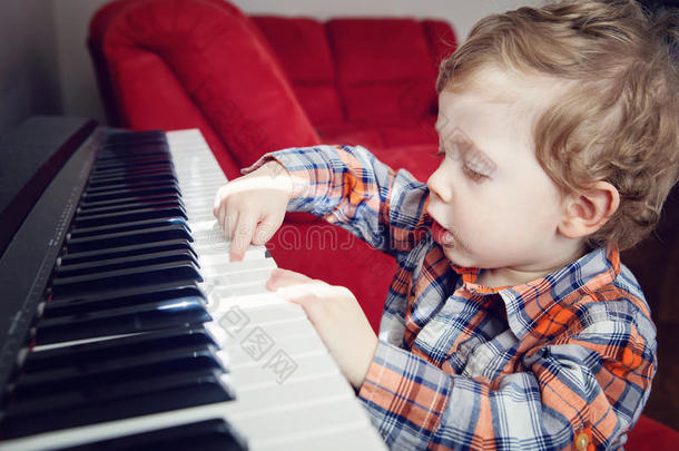可爱的白人白种人幼儿男孩弹钢琴的特写肖像