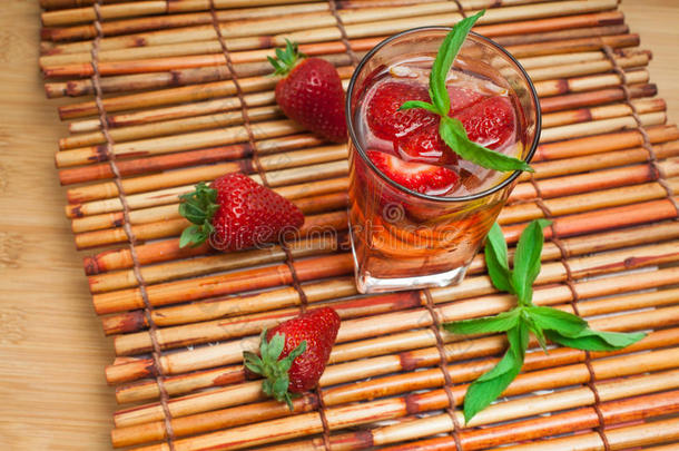 一杯草莓柠檬水，配上草莓、柠檬和新鲜薄荷。