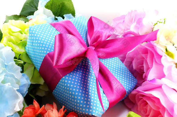 礼品盒与粉红色丝带蝴蝶结和美丽的彩色花朵背景