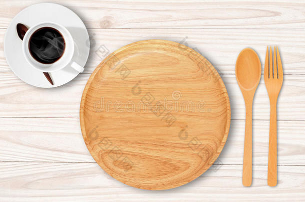 白色桌子上有勺子叉子和咖啡杯的空木盘子