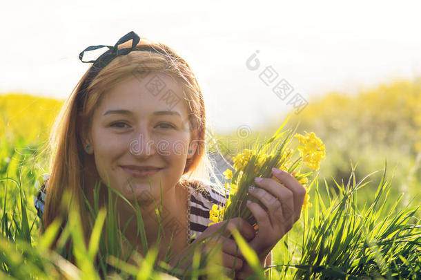 可爱的年轻女孩在一片鲜花的中间