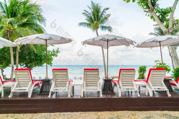 美丽的沙滩椅子，带着雨伞在户外游泳