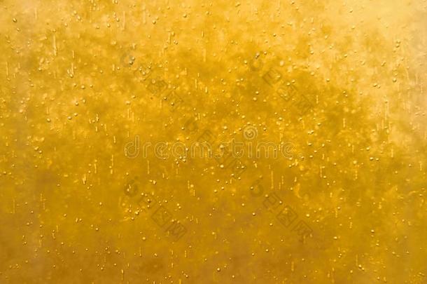 气泡漂浮在液体黄色饮料中，抽象图像。
