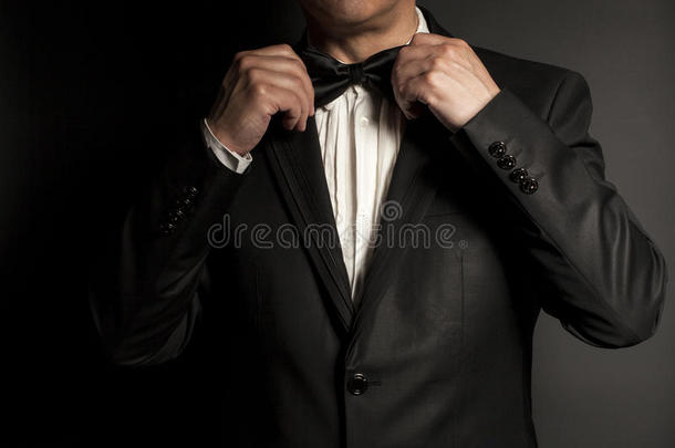 穿黑色领带的绅士的特写使他的领结伸直。