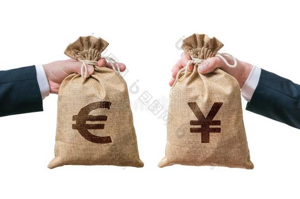 货币兑换概念。 手拿着装满钱的袋子-欧元和日元