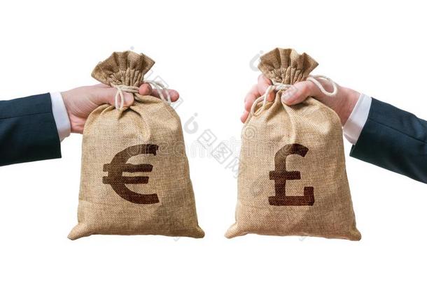 货币兑换概念。 手拿着装满<strong>钱</strong>的<strong>袋子</strong>-英镑和欧元