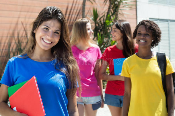 美丽的白种人女学生穿着蓝色衬衫和其他国际学生在一起