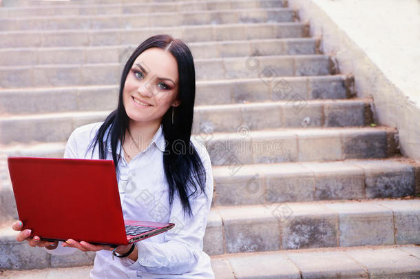 漂亮的<strong>商务</strong>女人坐在楼梯上拿着<strong>笔记本</strong>电脑