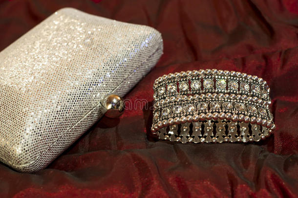 手镯有清晰的石头和闪亮的银色离合器袋。 时尚的配饰。 晚礼服的珠宝。
