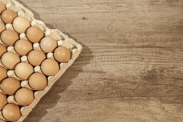把鸡蛋放在木制桌子上的纸箱包装上烤