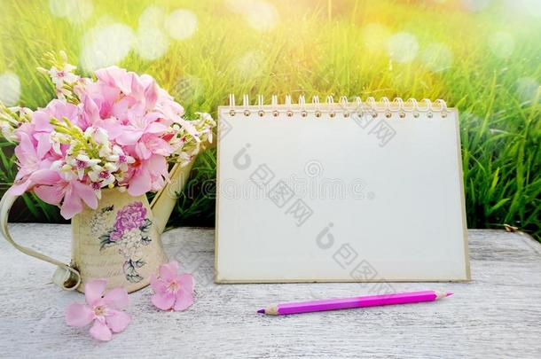 木桌上的花以柔和的柔和色调的波克自然绿草，包括空白页日历，铅笔早晨背景