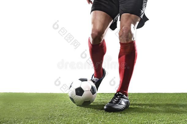 足球运动员穿着红色袜子和黑色鞋子跑步和运球，球在草地上打球