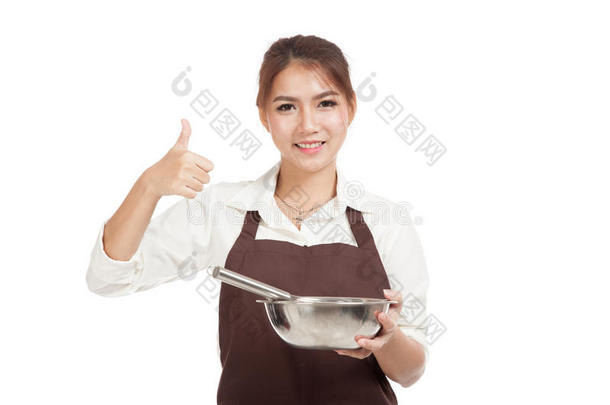 亚洲面包师女孩用<strong>打蛋器</strong>和碗展示竖起大拇指