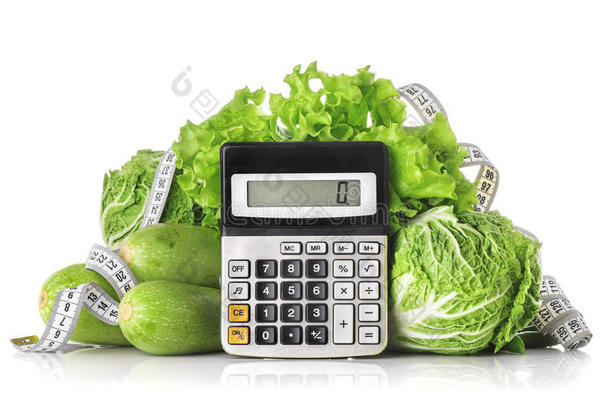绿色蔬菜，计算器和厘米隔离在白色上