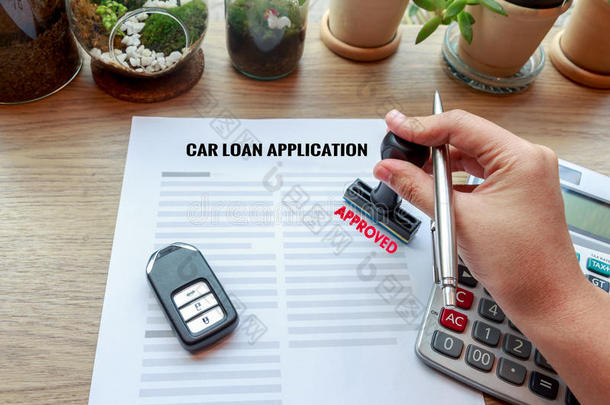 批准的汽车贷款申请与汽车钥匙，橡胶邮票和卡尔