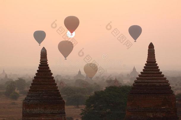 日出时在佛教寺庙上空放飞气球。 巴根