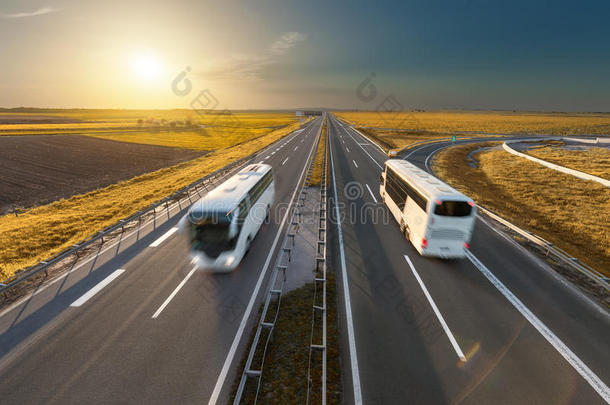在田园诗般的日落时，高速公路上的快速<strong>旅行巴士</strong>