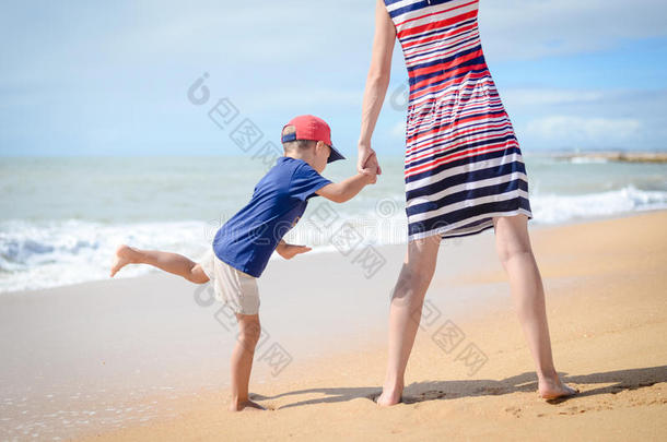 背面的快乐<strong>兴奋</strong>的母亲和孩子在阳光明媚的户外海滩上玩得很<strong>开心</strong>