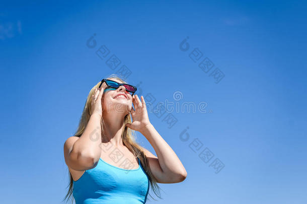 美丽的年轻女士用3D眼镜看电影，蓝光背景。