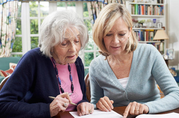 女邻居帮助老年妇女完成表格