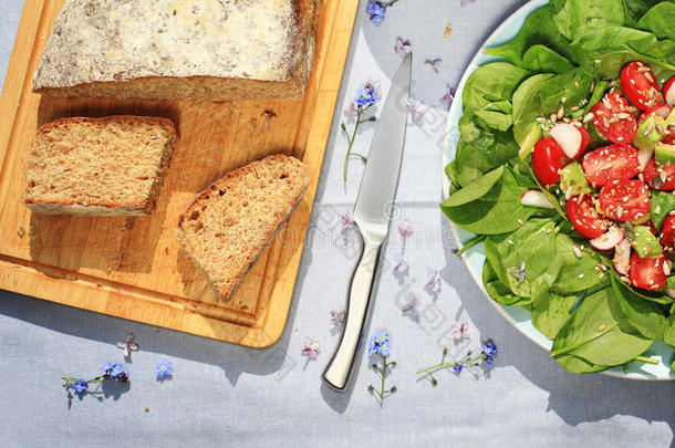 新鲜的，家庭烘焙苏打面包在木制切割板和新鲜素食沙拉