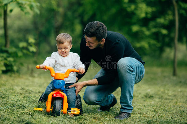 父亲帮助他的孩子骑