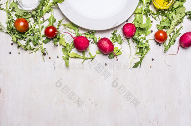 沙拉、萝卜、樱桃西红柿和调味料的不同成分，盘子排列在边框周围，放在文字顶部