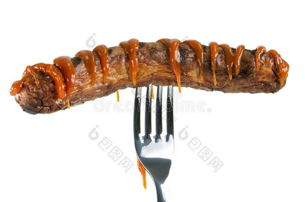 烤肠装饰番茄酱穿孔在叉子上，隔离在白色上