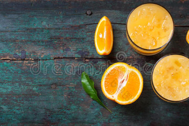 新鲜橙汁与碎冰，新鲜橘子和蓝色吸管在一个古老的复古异国背景