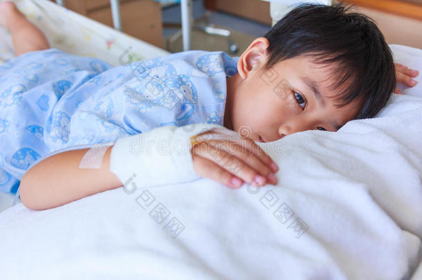 亚洲男孩躺在病床上，手上有生理盐水<strong>静脉注射</strong>(Iv。
