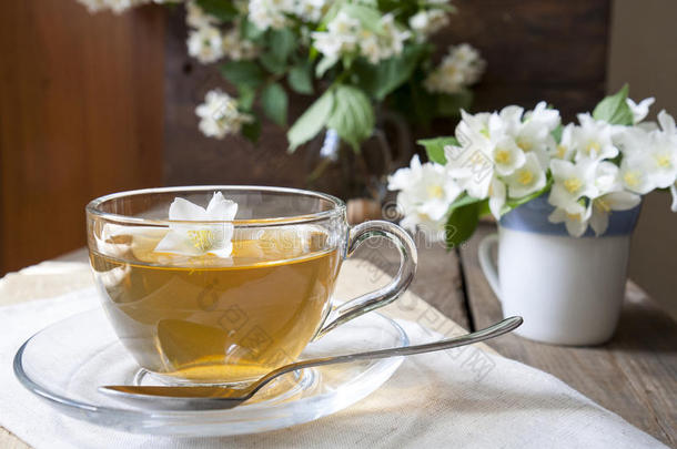 一杯带茉莉花和盛开的茉莉花枝的茶