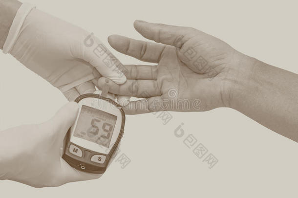 <strong>血糖</strong>仪，<strong>血糖</strong>值由戴白色医用手套的女医生在手指上测量