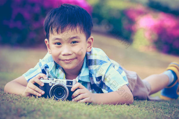 男孩用相机拍照，在公园<strong>探索大自然</strong>。 积极的生活方式，好奇心，追求爱好的概念。 古董。