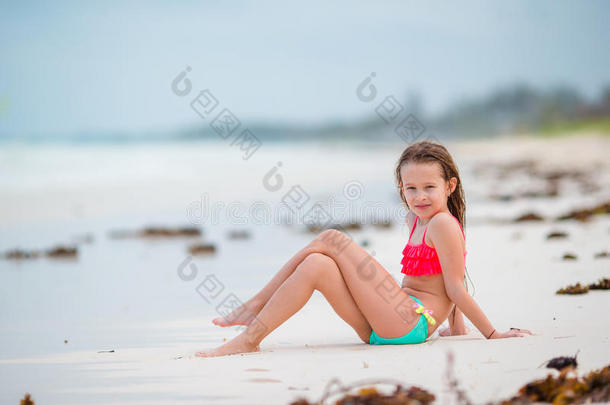 可爱的小女孩在白色海滩的浅水处玩得很开心