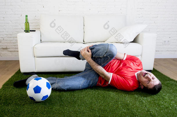 狂热的球迷在绿草地毯上模仿足球场球场嘲笑球员在<strong>脚踝</strong>上受伤