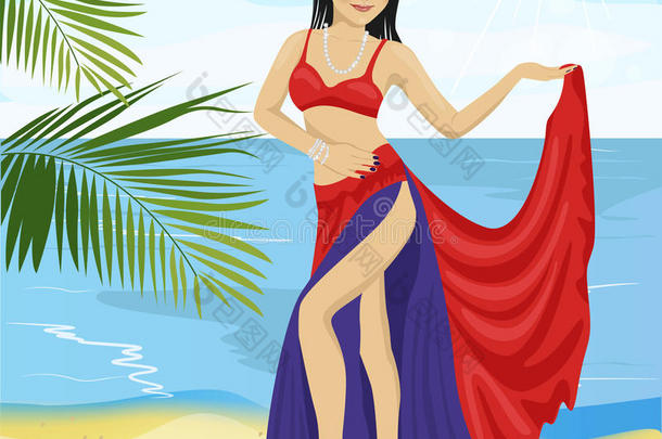 美丽的肚皮舞亚洲女人穿着红色和蓝色的舞台服装在海滩上