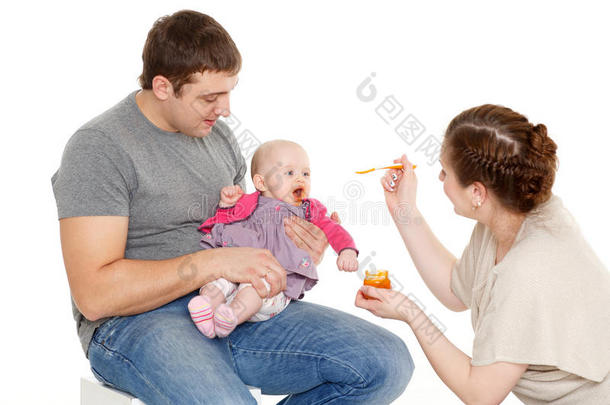年轻的父母给婴儿喂食。