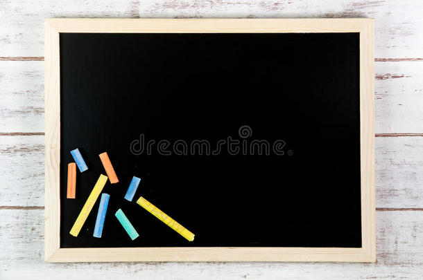 木制桌子上的空白黑板和彩色<strong>粉笔</strong>。<strong>模板</strong>模拟U