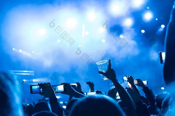 摇滚音乐会，快乐的人们举起手来的剪影