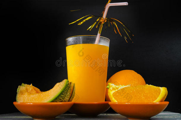 玻璃与新鲜冷榨甜瓜橙汁和新鲜水果