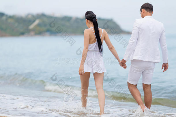 漂亮的一对白人夫妇沿着水边走，后视镜