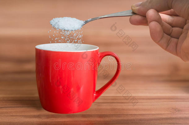 手在把糖倒进红茶里。 <strong>不</strong>健康的饮食观念