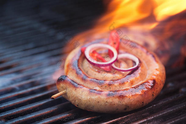 坎伯兰香肠，带火焰的烧烤架上的螺旋猪肉香肠，
