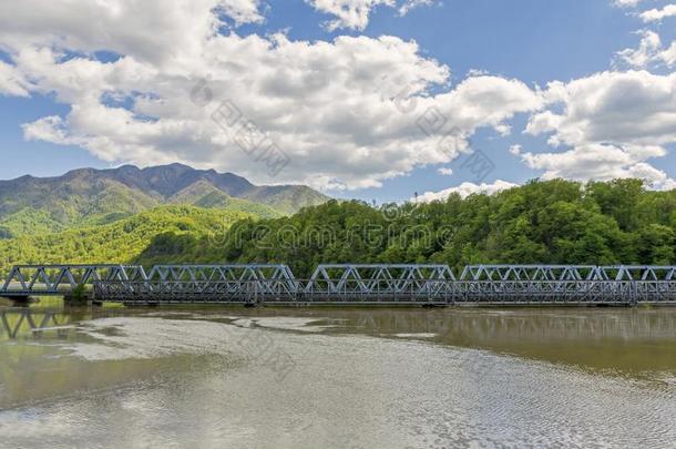 背景是一座横跨大河和群山的<strong>新旧</strong>桥