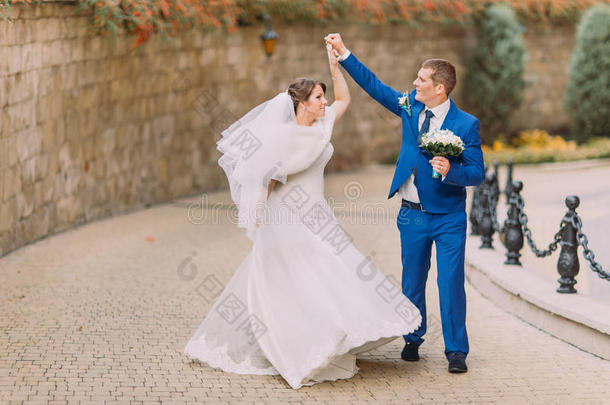 优雅美丽的新婚夫妇，<strong>漫步</strong>在<strong>公园</strong>附近的砂岩墙