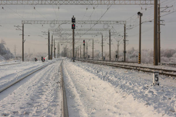 带有<strong>红色</strong>铁路信号的电气化铁路轨道-<strong>冬季</strong>带有交通标志的火车站