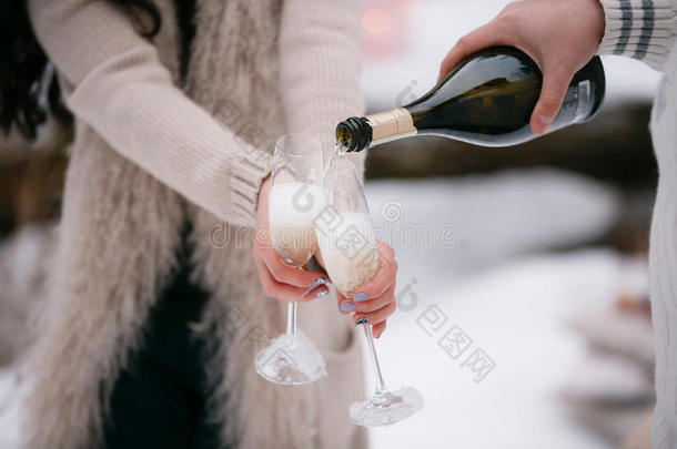 <strong>香槟</strong>倒在两个玻璃杯里。 冬天的森林